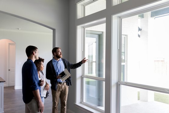 Real estate agent showing a house with large windows