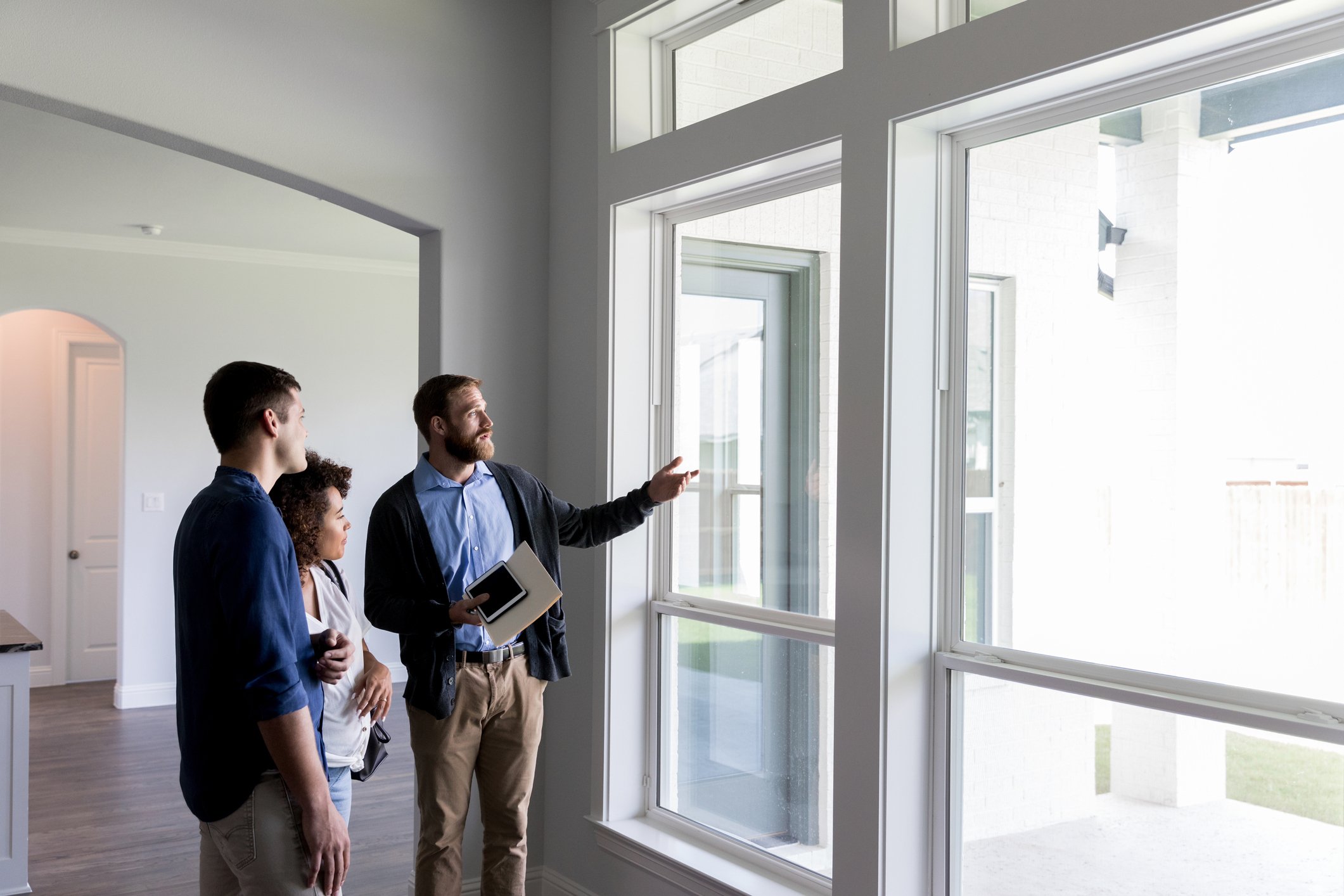 Real estate agent showing a house with large windows